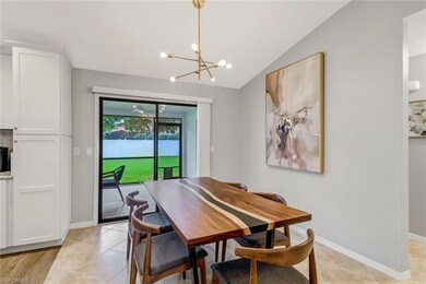 Dining space with light tile patterned floors, a chandelier, and lofted ceiling