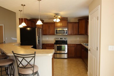The kitchen features stainless appliances and a ti