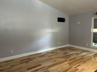 Unfurnished room featuring lofted ceiling and woo