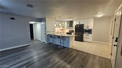 Kitchen with black appliances, a Quartz peninsula,
