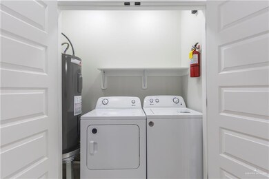 Washroom featuring water heater and washing machine and dryer