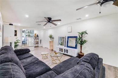 Living room featuring a ceiling fan, light wood-style floors, and recessed lighting