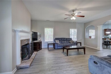Living area featuring plenty of natural light, arched walkways, ceiling fan, and baseboards