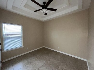 Unfurnished room with a raised ceiling, a ceiling fan, and baseboards