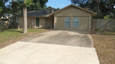 View of front of property with stone siding, a chimney, and concrete driveway