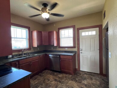 Kitchen with stainless steel appliances, dark tile patterned flooring, sink, and ceiling fan