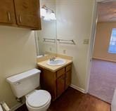 Bathroom with vanity, toilet, and baseboards