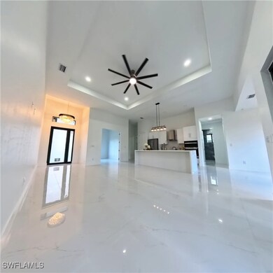 Unfurnished living room featuring a raised ceiling