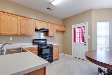 Kitchen with under cabinet range hood, black range