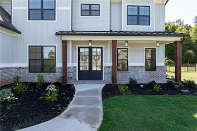Doorway to property with a lawn, covered porch, an