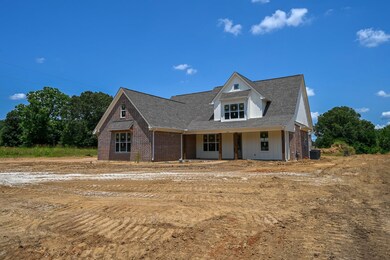 Modern farmhouse style home featuring brick siding, roof with shingles, and covered porch