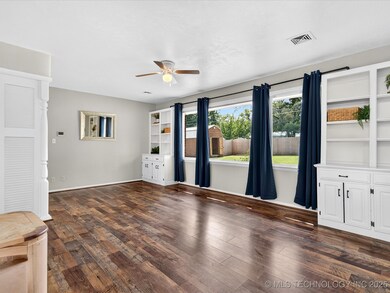 Formal living area with a wall of vinyl windows and built in bookshelves