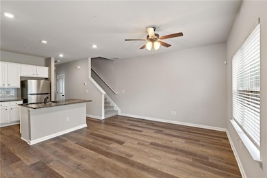 Kitchen with tasteful backsplash, white cabinets, 