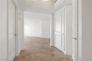 Hall with stone tile floors, baseboards, ornamenta