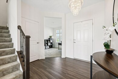 The Front Entry Glows With Light From the Beautiful Chandelier