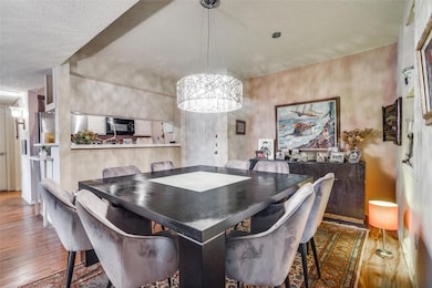 Dining space with a textured ceiling, hardwood / w