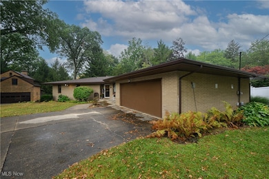 View of front of home featuring brick siding, a front lawn, an attached garage