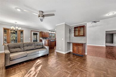 Living area featuring a ceiling fan, ornamental molding, a chandelier, recessed lighting, and dark tile patterned floors