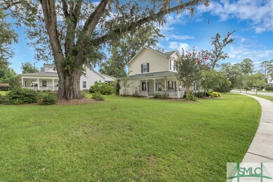 Side View of home showing porch and the mature tre