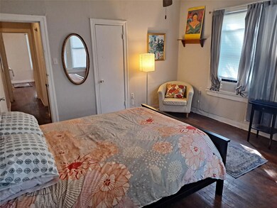 Bedroom featuring multiple windows, wood finished