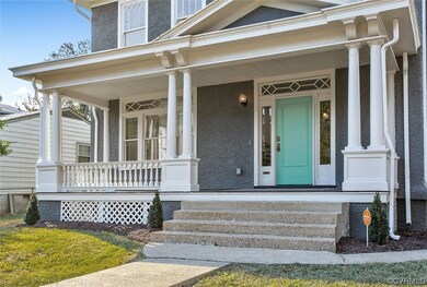 View of exterior entry featuring large covered porch and beautiful glass detail windows