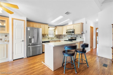Kitchen featuring a center island, light hardwood
