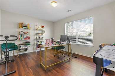 Home office with dark wood-style floors and a textured ceiling