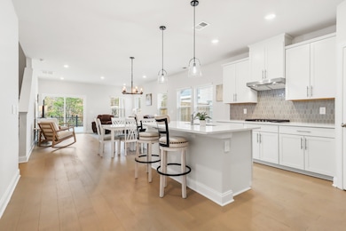 The open layout of the kitchen, eating, and living room space allows for easy entertaining