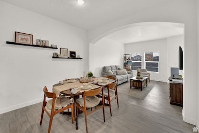 Dining space with arched walkways, light wood-type flooring, and recessed lighting