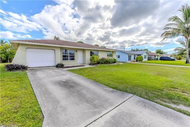 Ranch-style house featuring stucco siding, driveway, a front yard, and a garage