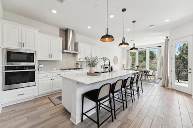 Kitchen with a sink, wall chimney range hood, sta
