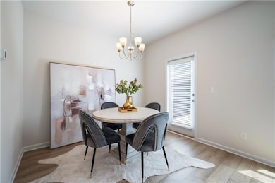 Dining space with light wood-style floors and a chandelier