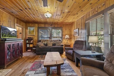 Living room featuring wood ceiling, wood walls, and light wood-type flooring