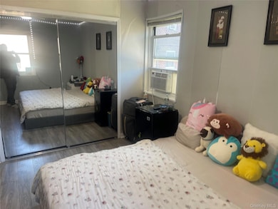 Bedroom featuring a closet, cooling unit, and wood finished floors