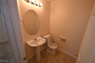 Half bathroom featuring tile patterned floors, toi