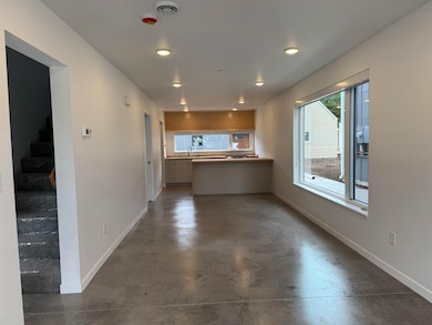 Unfurnished living room featuring concrete flooring, stairs, and recessed lighting