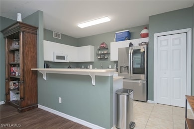 Kitchen featuring a breakfast bar area, white cabi