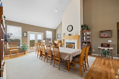 Dining space featuring high vaulted ceiling and wood finished floors