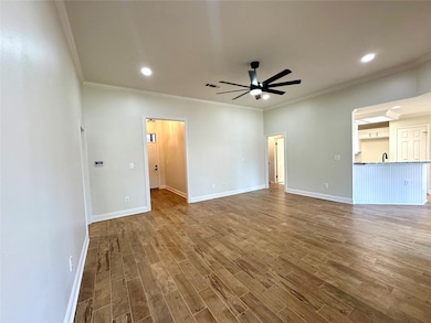 Unfurnished living room featuring ornamental molding, wood finished floors, a ceiling fan, and recessed lighting