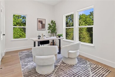Office area with baseboards and light wood-style flooring