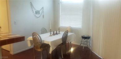 Dining space with dark wood-style floors and baseboards