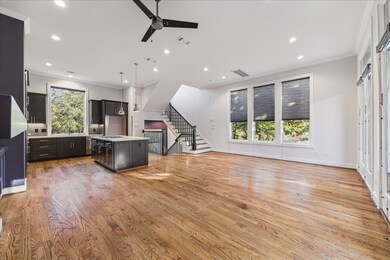 Bright and open, this expansive living and kitchen area is ideal for entertaining. The space features rich hardwood floors, soaring ceilings, and abundant natural light from oversized windows. The chef’s kitchen boasts a large island, sleek cabinetry, and stainless steel appliances—all seamlessly integrated into the open layout for effortless gatherings.