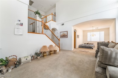 Living area with arched walkways, carpet, stairs,
