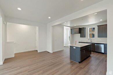 Kitchen with light countertops, recessed lighting, stainless steel dishwasher, light wood-style flooring, and a center island