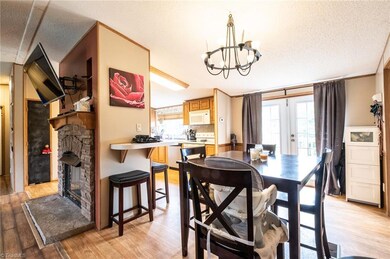 View of dining area, kitchen and stone fireplace in family room. Set of French doors leads to back deck.