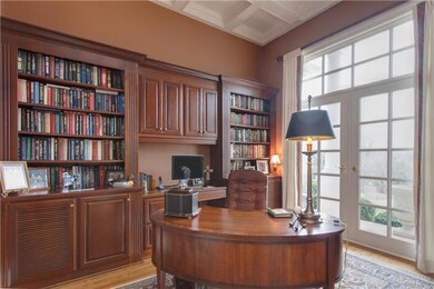 The library has beautiful coffered ceilings, custom built-in bookshelves and French doors leading to the front porch with a view of the hills. From the desk, you can also see the golf course - you'll want to spend more time working with these views!