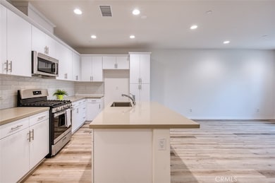 Open kitchen with quartz counters, breakfast bar island and custom cabinetry.
