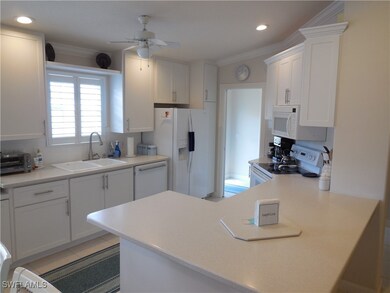 Kitchen with ceiling fan, crown molding, white cab