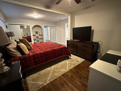 Bedroom with ceiling fan and dark hardwood / wood-style floors
