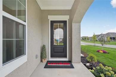 Entrance to property with stucco siding, a yard, a residential view, and covered porch